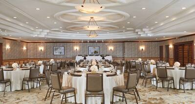 Round Dining Tables With Place Settings on White Linens in Sequoia Event Space  