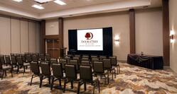 Salon A Meeting Room Arranged Theater Style With Rows of Chairs Facing Projector Screen and Podium