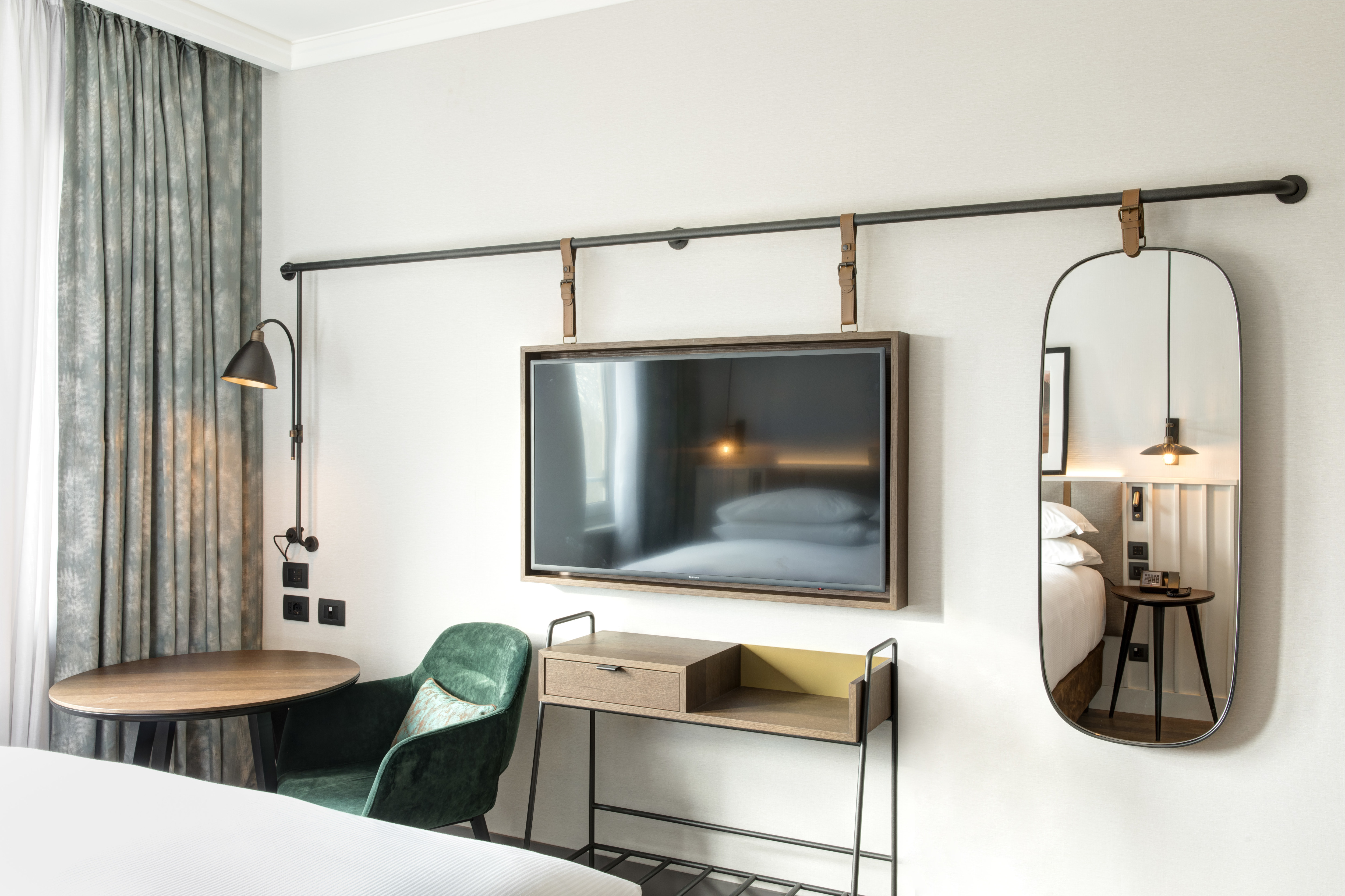 Camera da letto con TV a parete, scrivania e specchio a parete