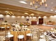 Ballroom Set Up With Place Settings and Flowers on Banquet Tables, Bar and Dance Floor
