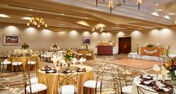 Ballroom Set Up With Place Settings and Flowers on Banquet Tables, Bar and Dance Floor
