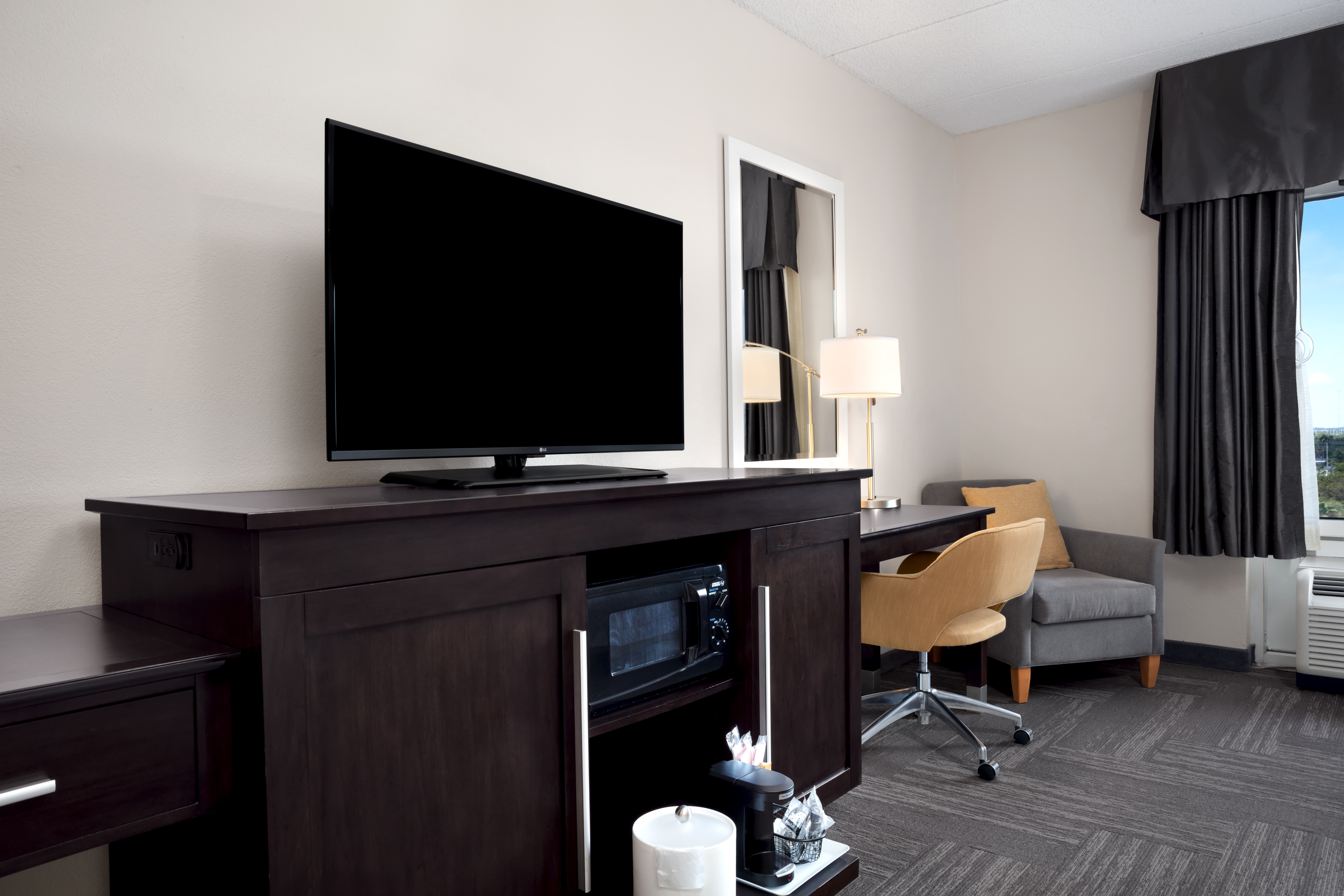 HDTV Microwave Coffemaker Work Desk and Armchair in Hotel Guest Room 