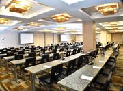Classroom Setup in Ballroom With Wall Art, Tables and Grey Chairs Facing Presentation Screens