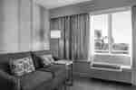 Suite tamu yang santai dengan sofa mewah dan cahaya alami yang cukup