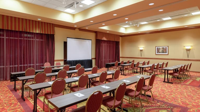 Tables and Chairs in Classroom Style Setup with Projector Screen in Lake Loveland A and B Meeting Rooms