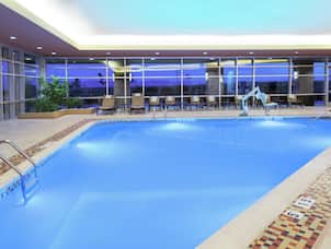 Indoor Pool with Pool Access Hoist and Lounge Chairs on Pool Deck