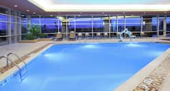 Indoor Pool with Pool Access Hoist and Lounge Chairs on Pool Deck