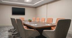 Spacious on-site boardroom featuring large table and TV at front of room.