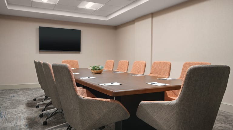Spacious on-site boardroom featuring large table and TV at front of room.