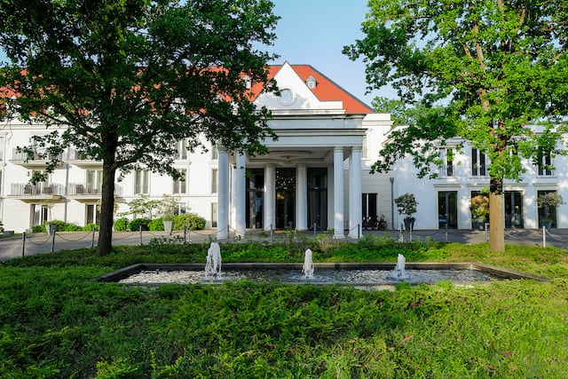 Hotel exterior with water feature and greenery