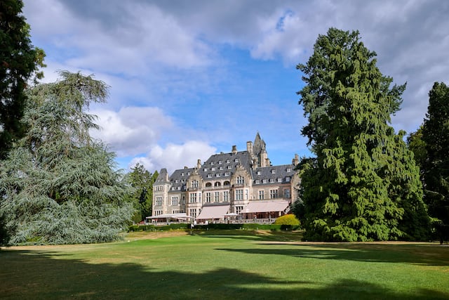 Castle with large garden grass area and trees