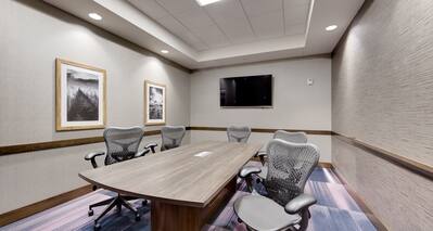 Meeting Room with Table, office Chairs and Wall Mounted HDTV