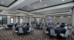 Spacious Ballroom with Round Tables, Chairs and Projector Screen