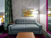 King studio sofa with wall mirror and king bed in background