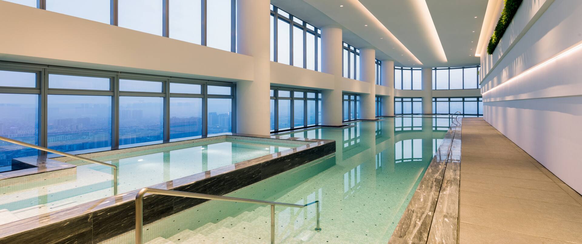 Indoor Pool Area with Large Windows Offering City View