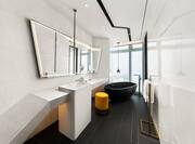 Bathroom Vanity Area and Bathtub next to a Window with City View