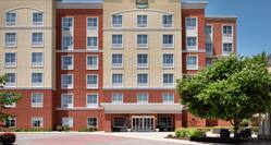  Welcoming Homewood Suites hotel featuring bright blue skies and lush trees.