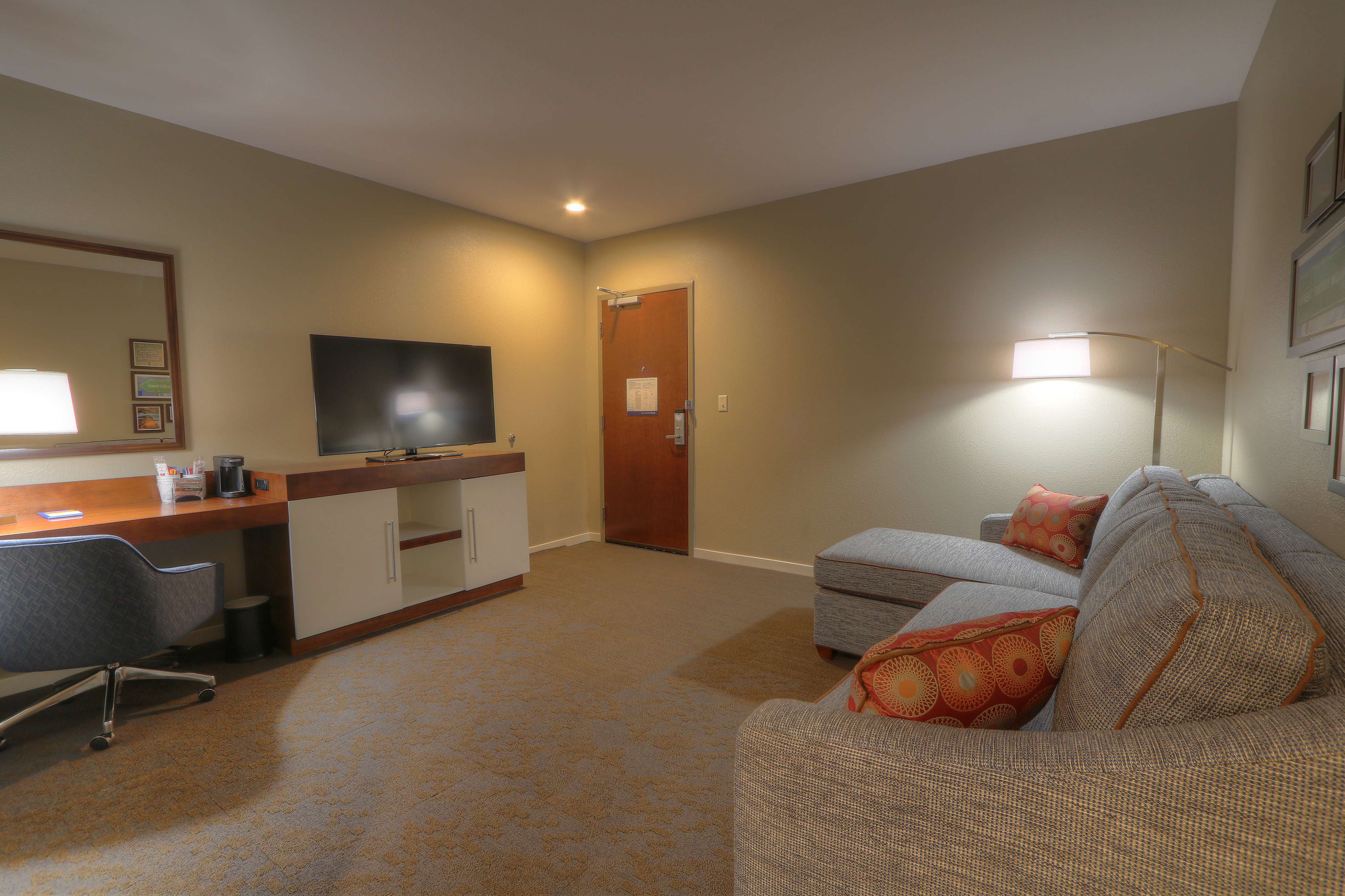 Guest Room Lounge Area with Sofa, Work Desk and HDTV