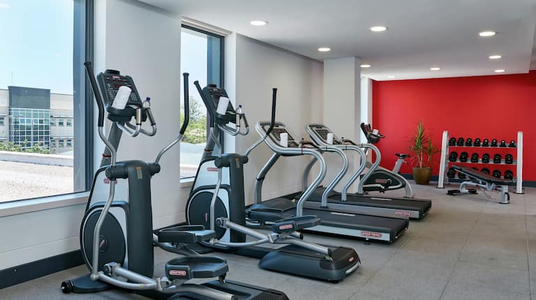 Fitness Center with Elliptical Machines, Treadmills, Dumbbells, and Outside View