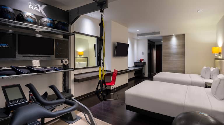 Guest Room with Two Beds Desk HDTV and Fitness Equipment