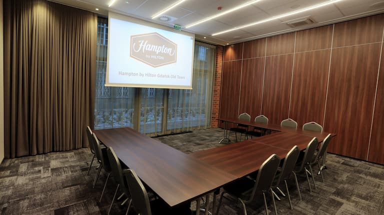 Chairs and U-Shaped Table with Projector Screen in Conference Room