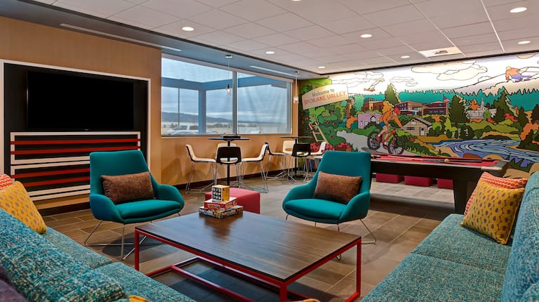 lobby seating area with mural and pool table