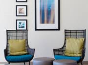 Lobby chairs and stools near displayed artwork 