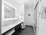 King bathroom with sink mirror and shower