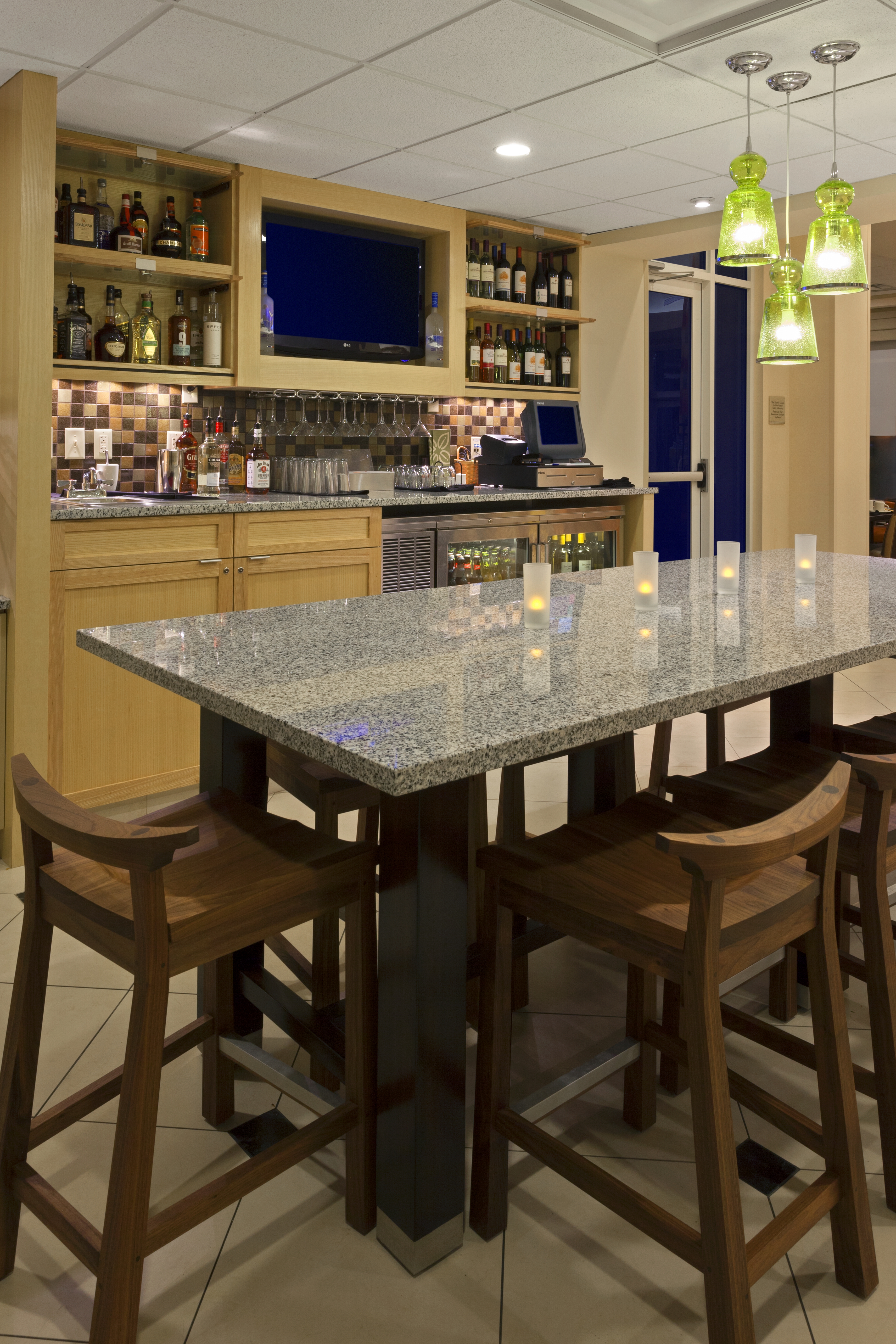 Fully stocked lobby bar with a high-top table and chairs