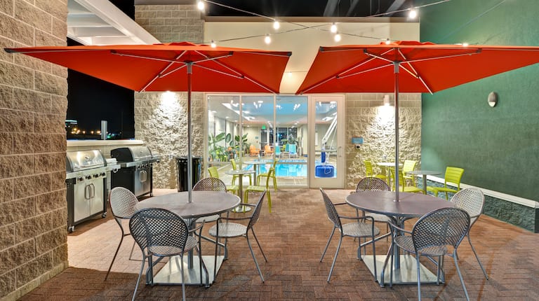 Outdoor Patio at night with Tables, Chairs, Umbrellas and Grills