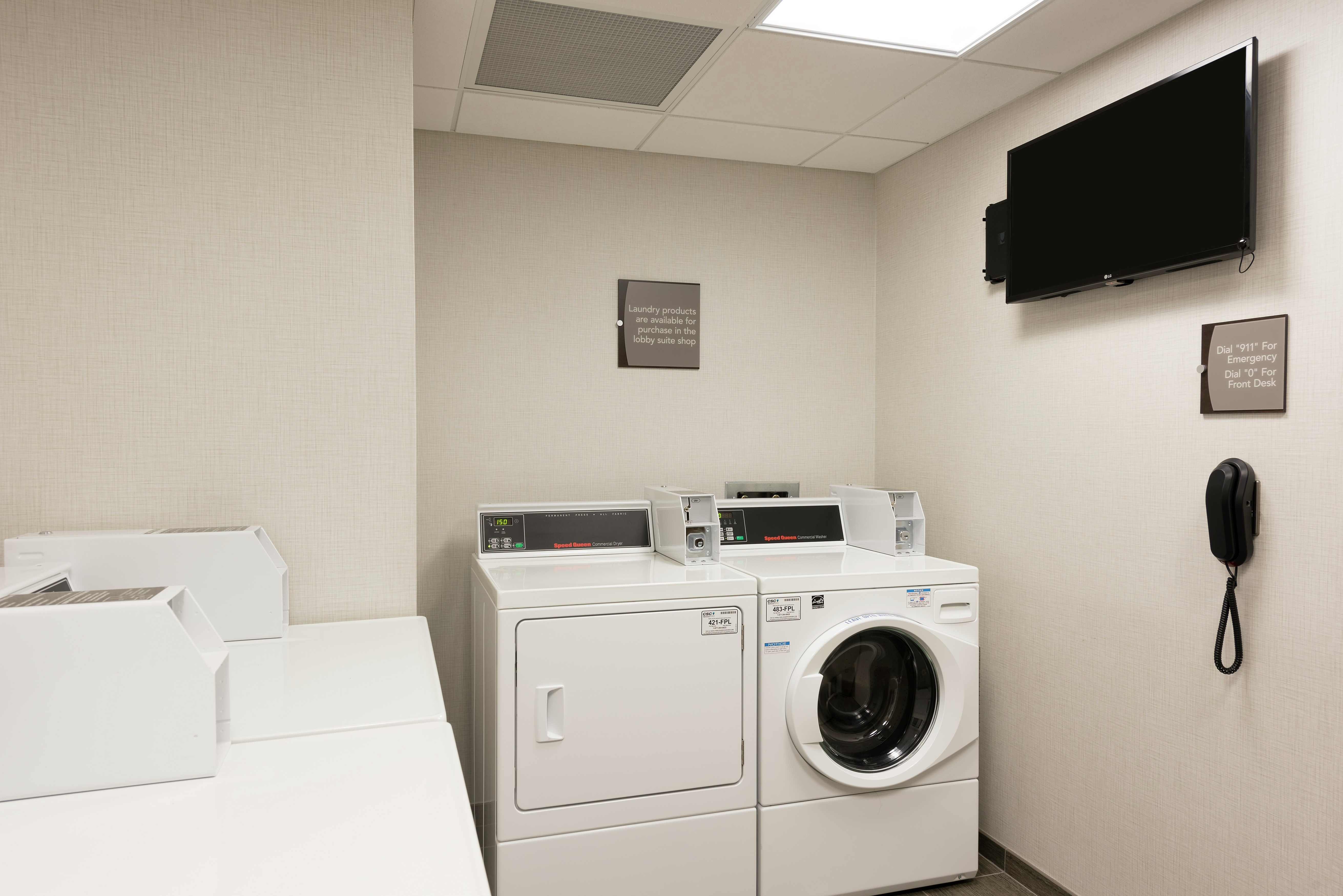 Coin Operated Washing and Drying Machines, TV, Signage, and Phone in Guest Laundry Area