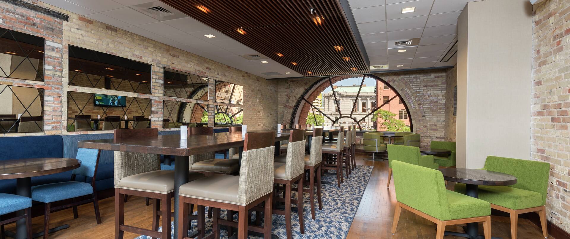 Tables, Chairs, and Booth Seating In Dining Area With Large Semicircle Windows