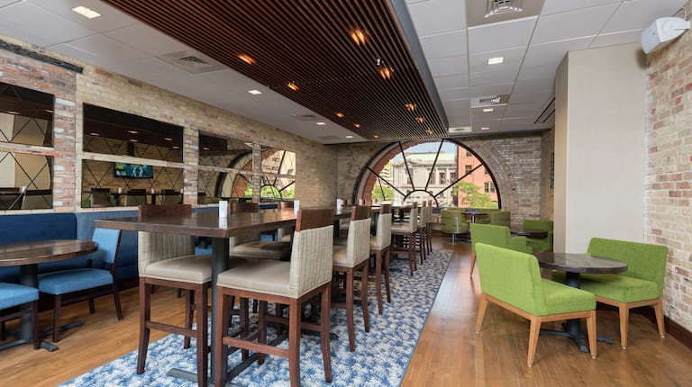 Tables, Chairs, and Booth Seating In Dining Area With Large Semicircle Windows