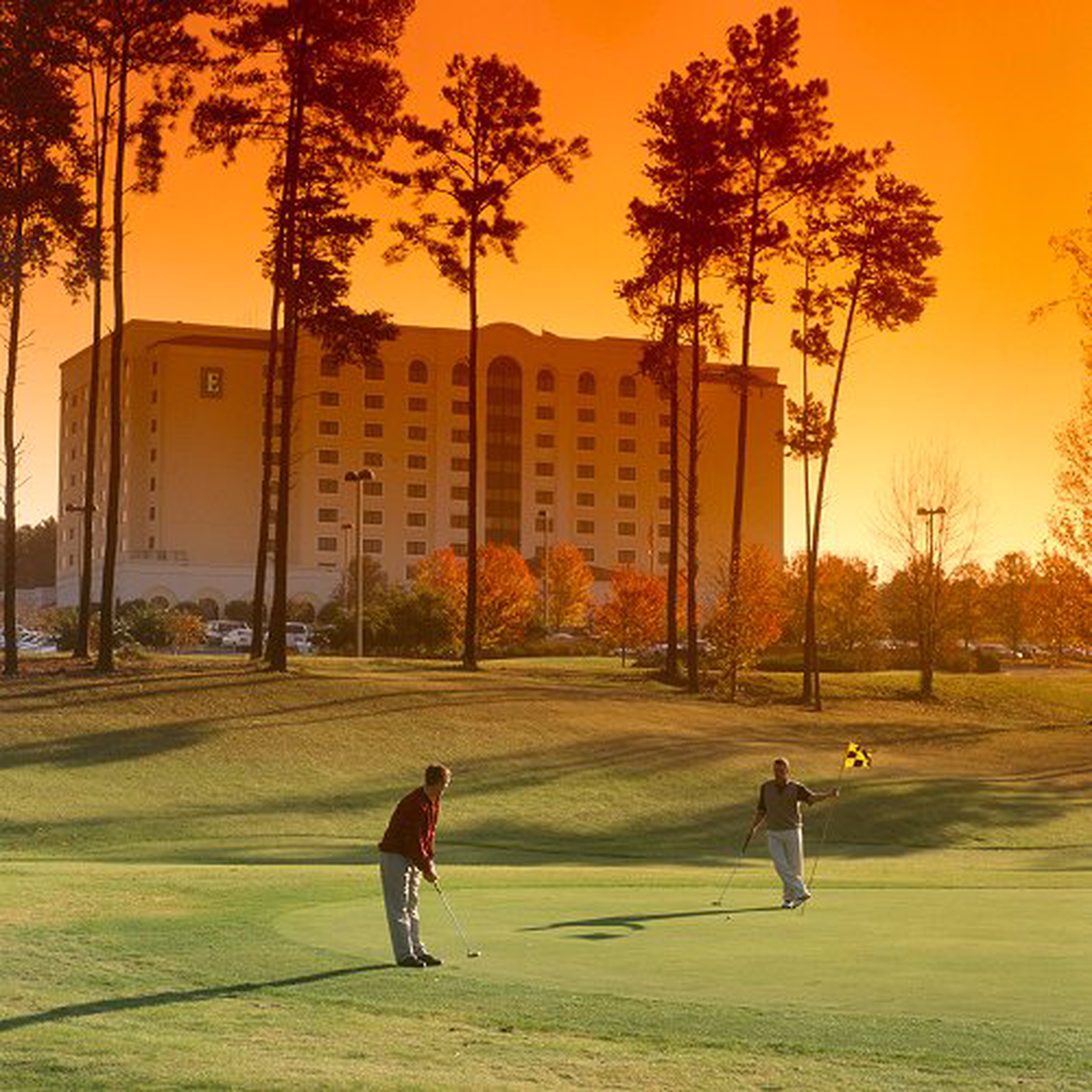 Men golfing at sunset 