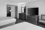 Two beds in guest room with TV on storage cabinet