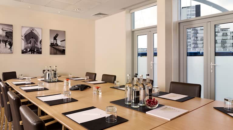 Meeting Room With Oval Table and Chairs in Boardroom Setting With Outside View From Windows