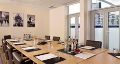 Meeting Room With Oval Table and Chairs in Boardroom Setting With Outside View From Windows