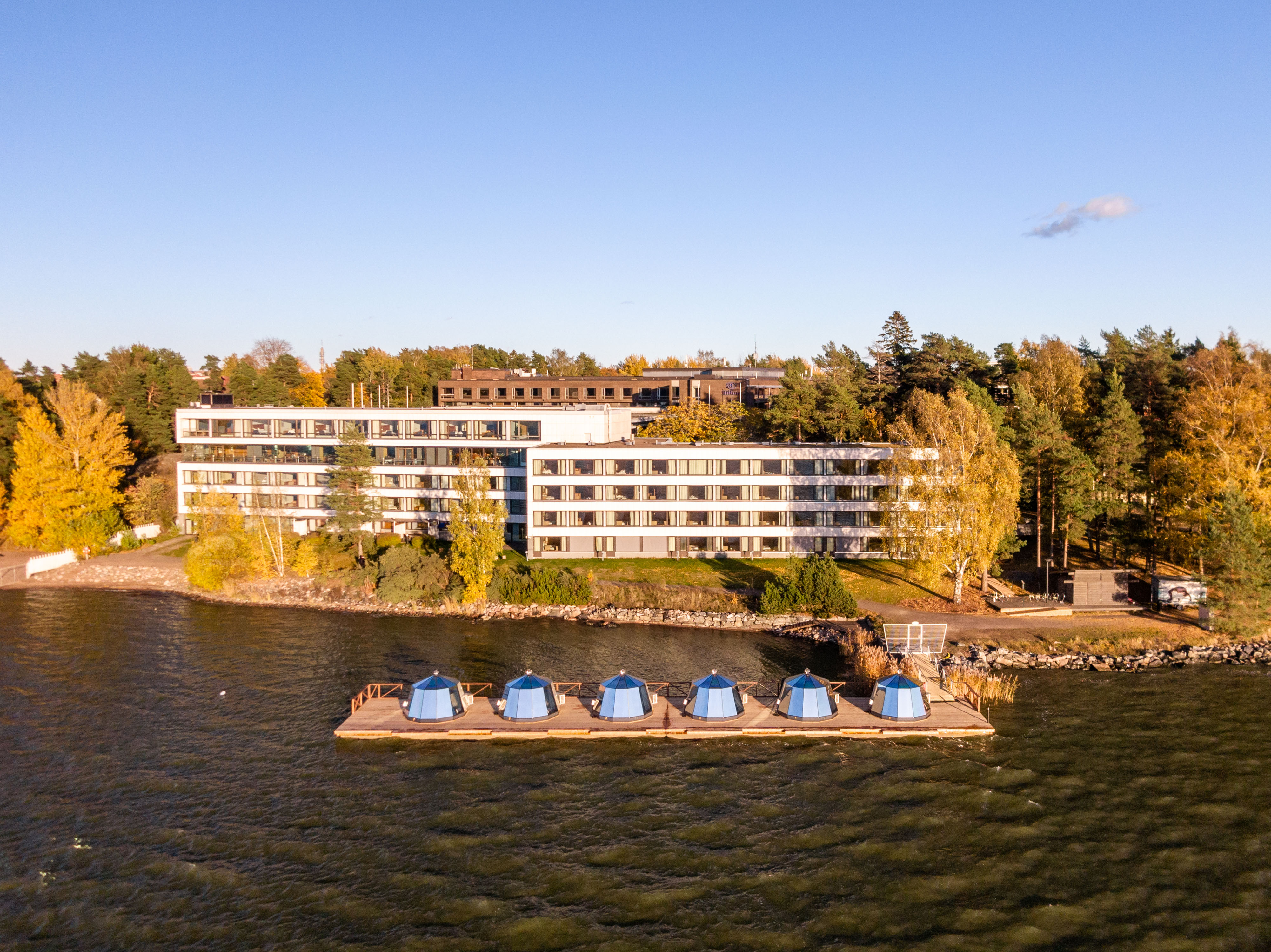 iglux on water with aerial view of hotel