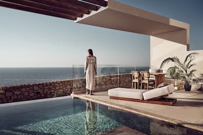 Frau, die am privaten Außenpoolbereich eines Zimmers steht