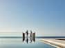 Couple Standing by the Infinity Pool Area with View of the Sea