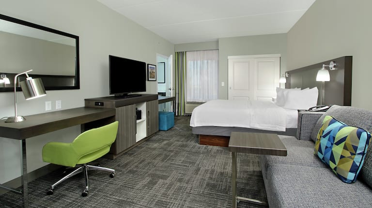 King Bed, TV, Work Desk, and Lounge Area in Whirlpool Suite