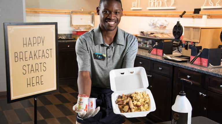 Hotel Employee with To Go Breakfast Options