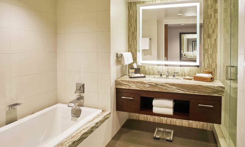 Alii Ocean Front Guestroom Bathroom with Mirror, Vanity, Bathtub, and Walk-In Shower-previous-transition