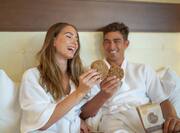 Couple eating cookies in bed