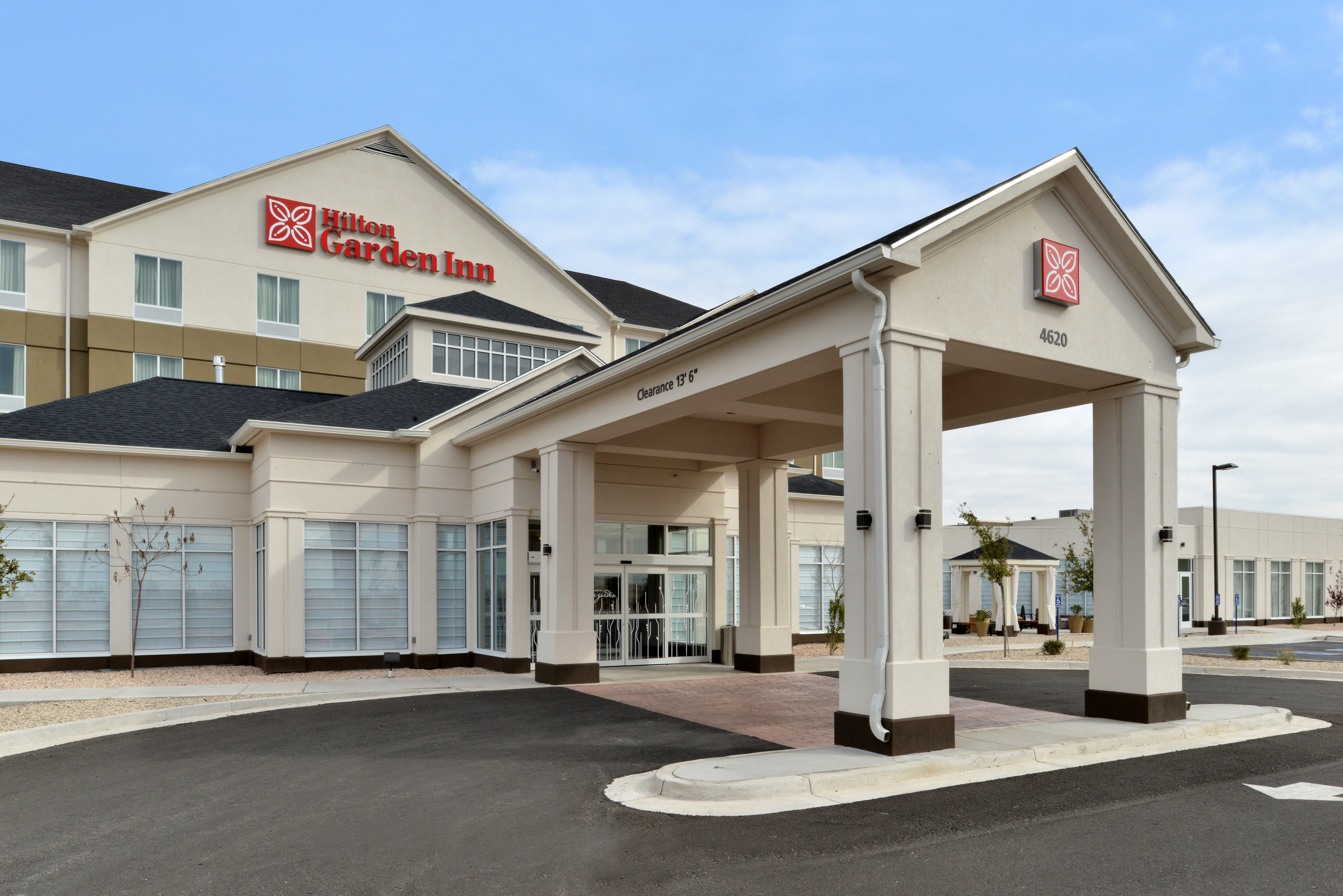 Daytime View of Hotel Exterior, Signage, Landscaping, Circle Driveway, and Parking Lot