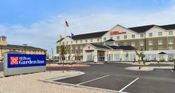 Daytime View of Hotel Exterior, Signage, Flagpoles, Landscaping, Circle Driveway, and Parking Lot