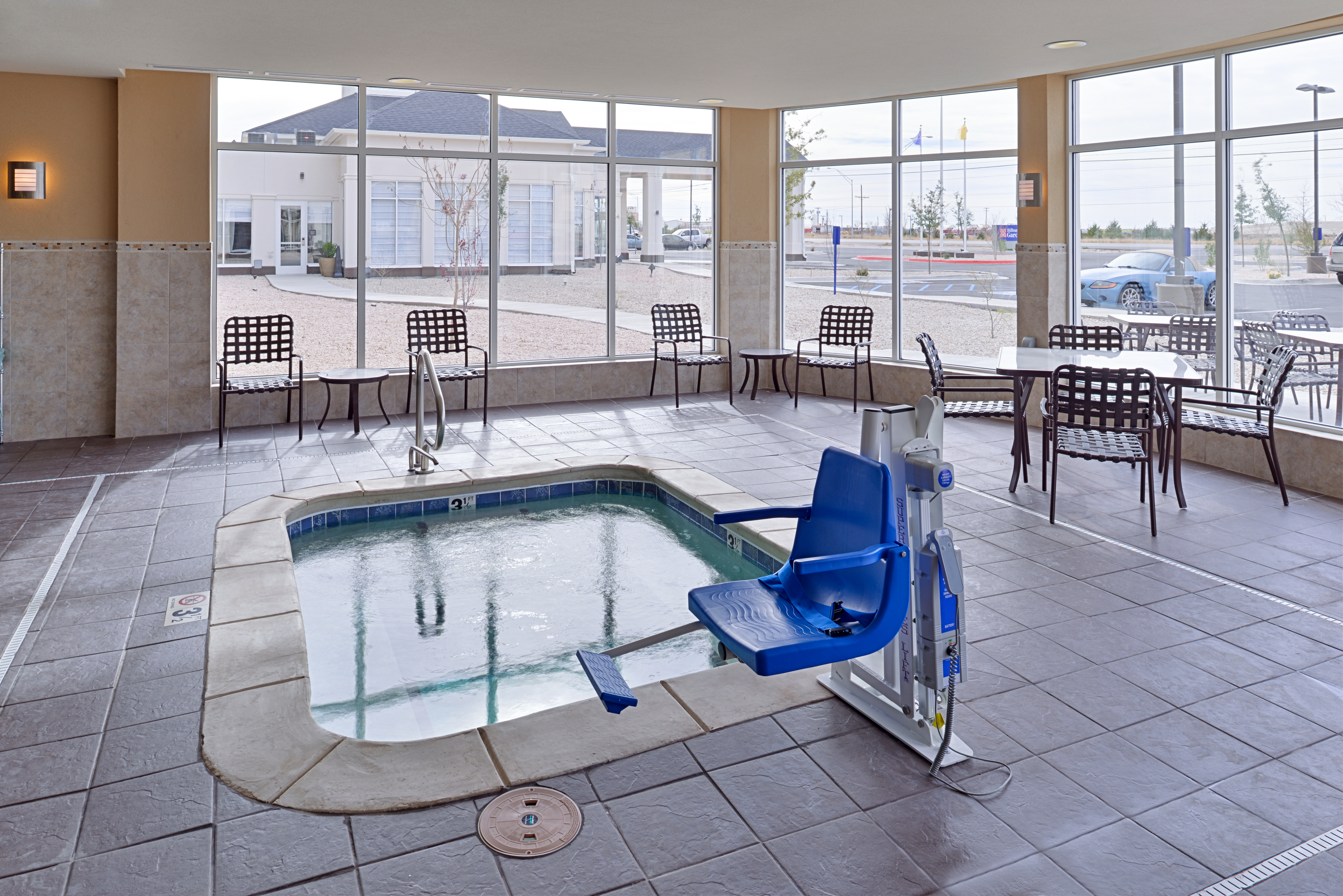 Hot Tub Surrounded by Windows, Tables, and Chairs