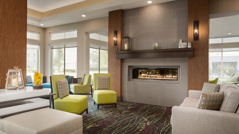 Lobby seating area with sofa, ottoman, chairs, and fireplace