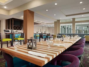 Restaurant dining area with long table, chairs, and dining amenities