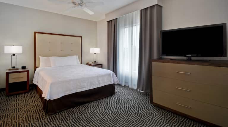 guest room with bed television and window
